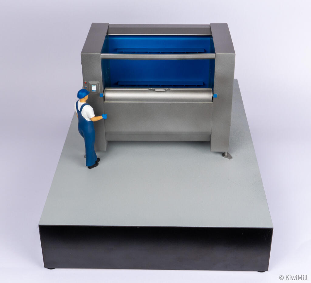 Overhead front view of the belt chiller model over its long base, showing blue belt flights and centered lip handle
